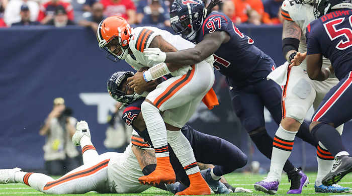 Deshaun Watson is tackled by two Texans players in his first game for the Browns.